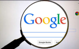 A magnification glass is over the Google search on a website